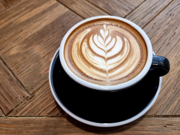 Seitlicher Shop-Kaffee eine Tasse heißer Latte-Art-Kaffee auf Holzhintergrund