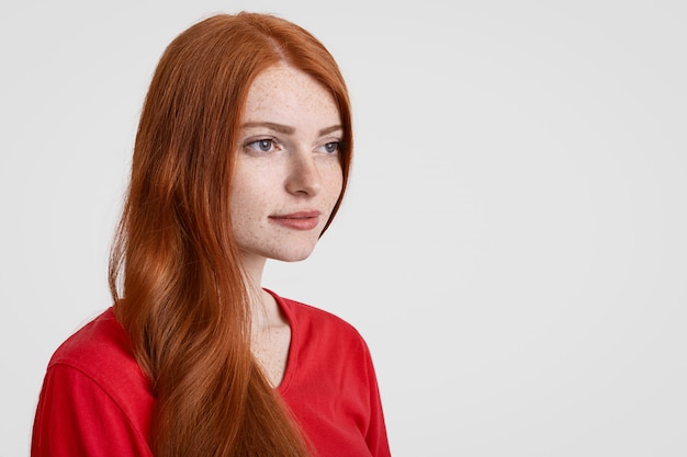 Foto seitwärtsaufnahme der schönen rothaarigen sommersprossigen frau mit langen haaren