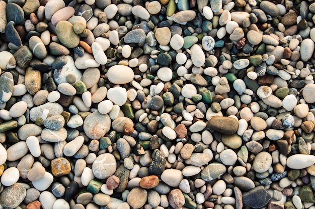 Seixos de pedra da praia. a textura de pequenas pedras e areia. pode ser usado como pano de fundo de textura