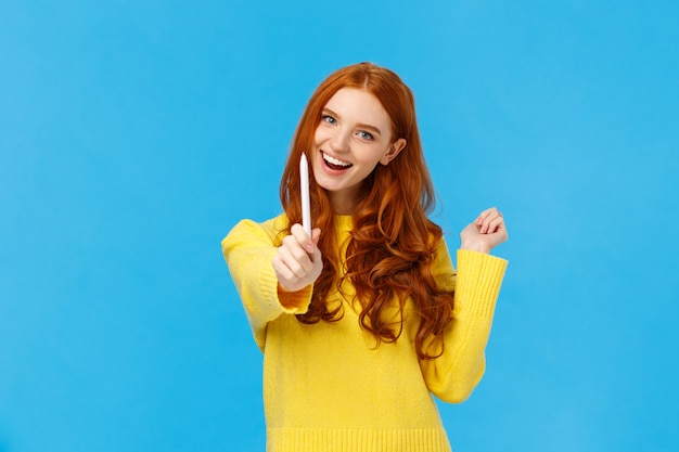 Seja autor de seu próprio futuro. Mulher ruiva animada alegre e criativa, dando-lhe caneta