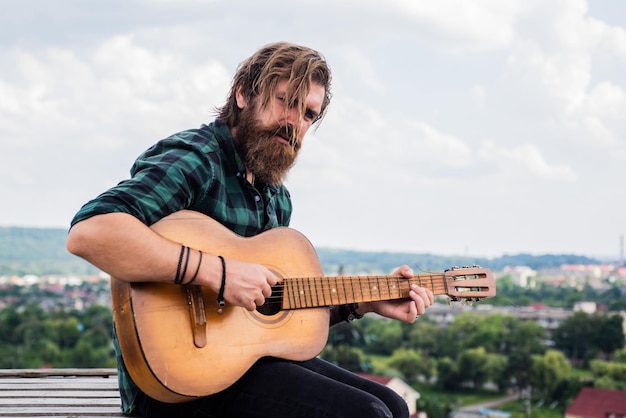 Seja famoso cara caucasiano brutal tocando guitarra música country homem barbudo cantando música homem bonito cantor e guitarrista guitarrista acústico maduro hipster músico com barba