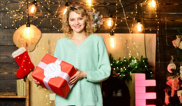 Seja generoso Coisas para fazer antes do natal Mulher segura caixa de presente fundo de decorações de natal Natal é de longe o mais esperado para o feriado do ano Menina com presente Caridade e bondade