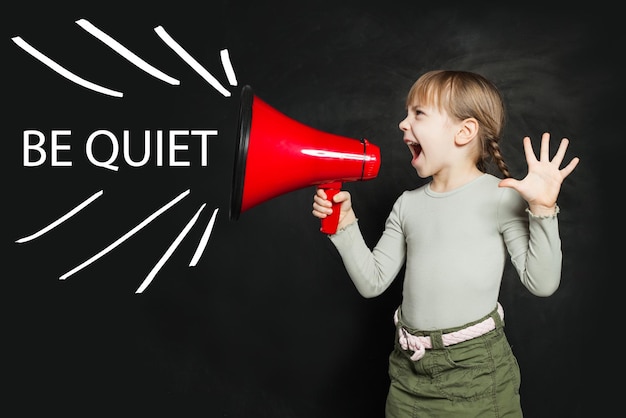 Seja tranquilo conceito menina engraçada gritando alto através de um megafone Seja tranquila