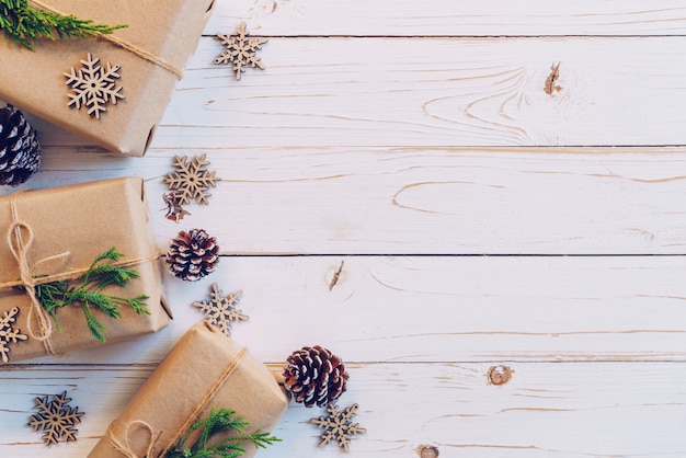 Selbst gemachte eingewickelte Weihnachtsgeschenkbox stellt sich auf einem hölzernen Tabellenhintergrund dar.