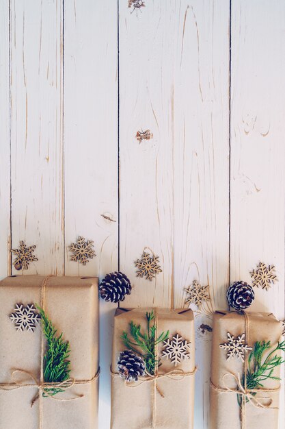 Selbst gemachte eingewickelte Weihnachtsgeschenkbox stellt sich auf einem hölzernen Tabellenhintergrund dar.