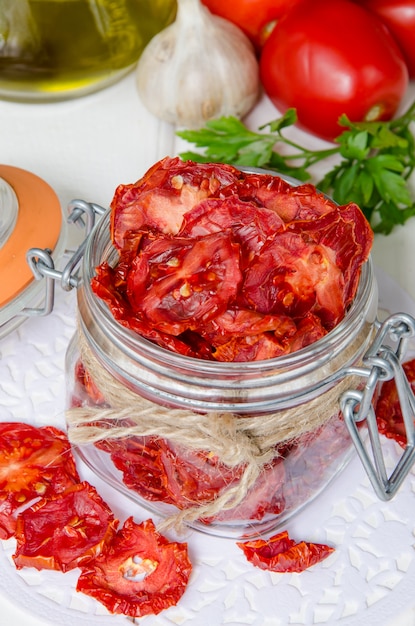 Selbst gemachte getrocknete Tomaten in einem Glasgefäß auf einem hölzernen