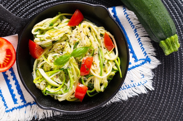 Selbst gemachte Guilten-Freie Zucchini-Nudeln des gesunden Lebensmittelkonzeptes, Teigwaren mit Tomate in der Eisenbratpfannenwanne