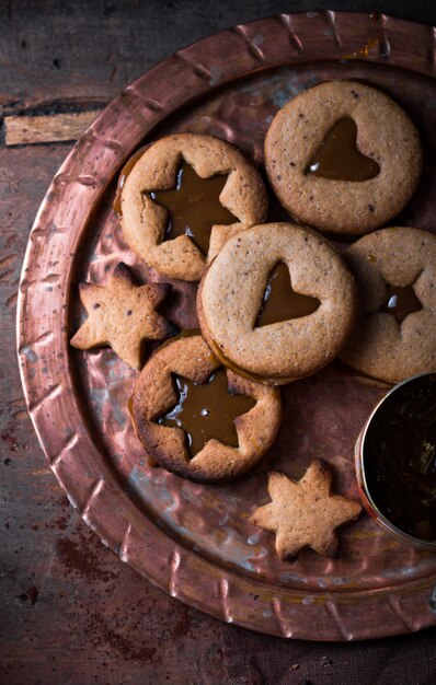 Selbst gemachte Karamellplätzchen der Sternform des Weihnachtsneujahrs über Holzhintergrund. Flache Lage, Platz.