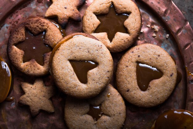 Selbst gemachte Karamellplätzchen der Sternform des Weihnachtsneujahrs über Holzhintergrund. Flache Lage, Platz.