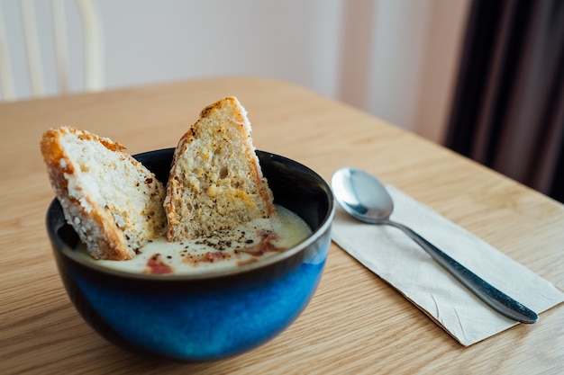 Selbst gemachte Kartoffelsuppe diente mit Sauerteigbrot auf dem Holztisch