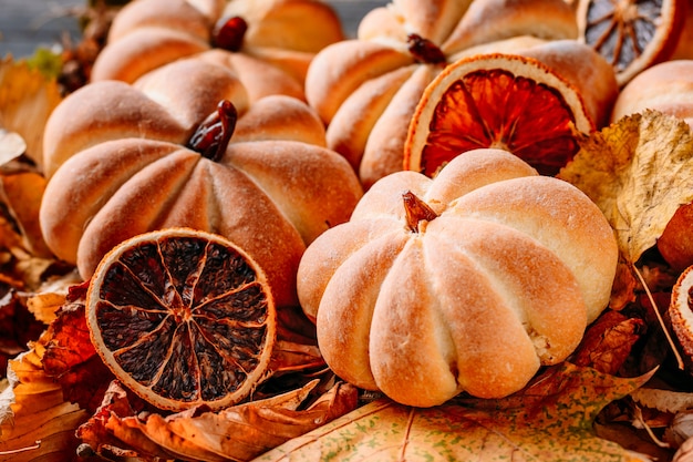 Selbst gemachte Kuchen in Form des Kürbises mit Herbstlaub schließen oben. Halloween-Bonbonkonzept