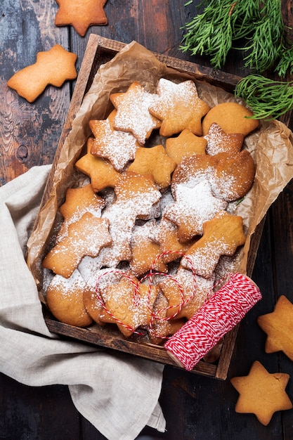 Selbst gemachte Lebkuchenplätzchen der Weihnachts-Neujahrssternform in der Holzkiste auf alter hölzerner Weinleseoberfläche