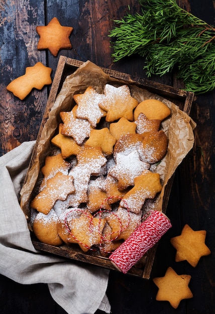 Selbst gemachte Lebkuchenplätzchen der Weihnachts-Neujahrssternform in der Holzkiste auf alter hölzerner Weinleseoberfläche