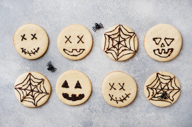 Selbst gemachte Plätzchen für Halloween, Plätzchen mit lustigen Gesichtern und Spinnennetzen