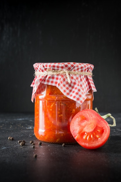 Selbst gemachter Adjika mit Tomaten im Glas