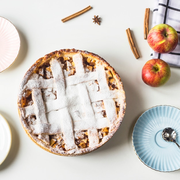 Selbst gemachter Apfelkuchen besprüht mit Puderzucker auf einer weißen Tabelle