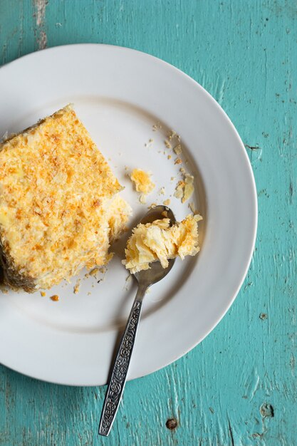 Selbst gemachter Blätterteigpuddingcremetorte auf blauem hölzernem Hintergrund