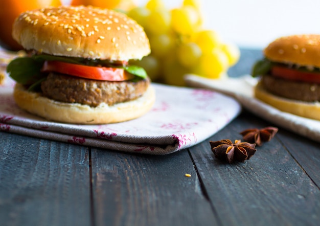 Selbst gemachter Burger mit Gemüsegewürzen und Rindfleisch auf einem hölzernen