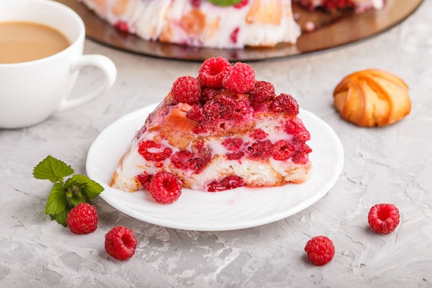 Selbst gemachter Geleekuchen mit Milchplätzchen und Himbeere auf einem grauen konkreten Hintergrund mit Tasse Kaffee