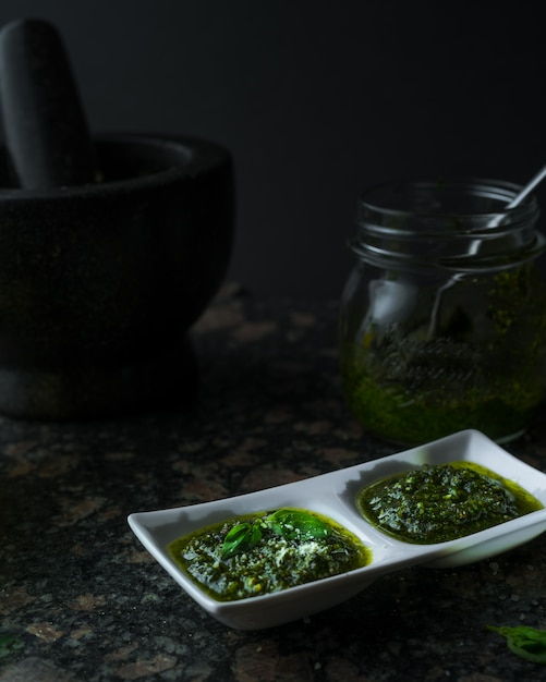 Selbst gemachter grüner Pesto auf dunklem Hintergrund