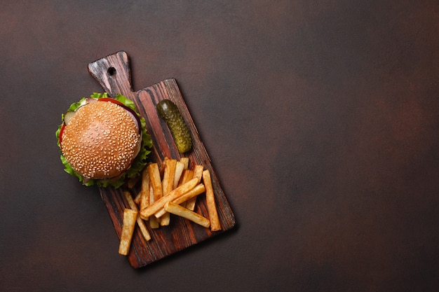 Selbst gemachter Hamburger mit Bestandteilen Rindfleisch, Tomaten, Kopfsalat, Käse, Zwiebel, Gurken und Pommes-Frites