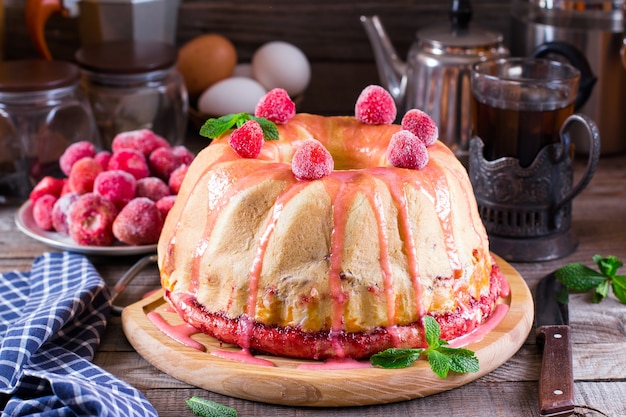 Selbst gemachter Hefekuchen mit Erdbeermarmelade auf einem alten Holztisch