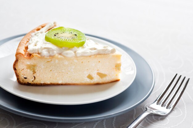 Selbst gemachter Hüttenkäsekuchen mit Kiwi und Sahne