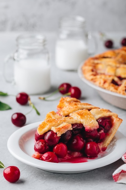 Selbst gemachter Kirschkuchen mit einer flockigen Kruste auf grauem Steinhintergrund