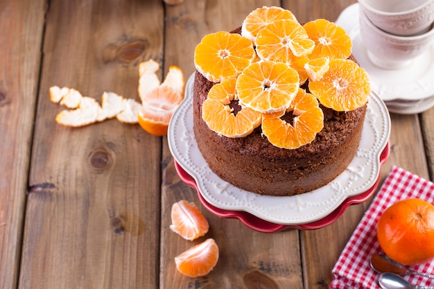 Selbst gemachter kleiner Kuchen mit Tangerinen auf einer weißen Platte