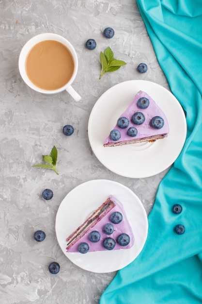 Selbst gemachter Kuchen mit Auflaufcreme und Blaubeermarmelade mit Tasse Kaffee. Ansicht von oben.