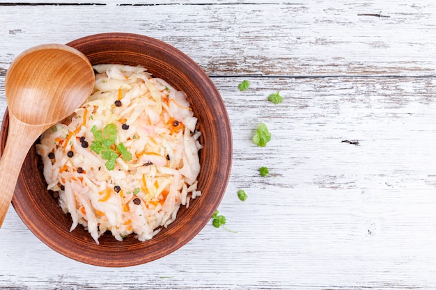 Foto selbst gemachter marinierter kohl, sauerkraut sauer im hölzernen schüssel-küchentisch