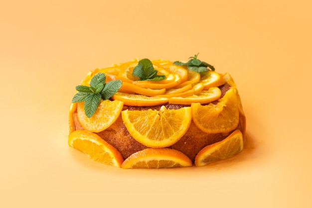 Foto selbst gemachter orangenkuchen mit geschnittenen orangen über lokalisiertem hintergrund