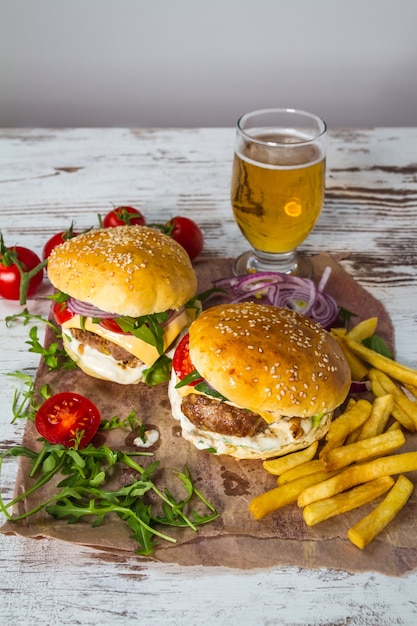 Selbst gemachter Rindfleisch-Burger mit Käse und Chips auf hölzernem Hintergrund