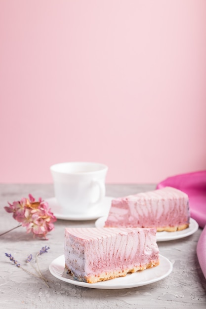 Selbst gemachter rosa Käsekuchen mit Tasse Kaffee. Seitenansicht