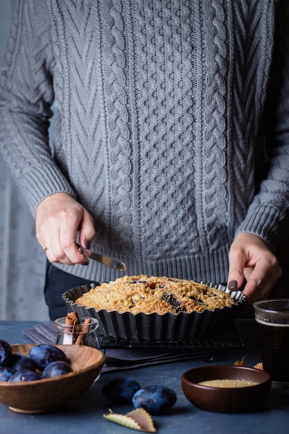 Selbst gemachter rustikaler Pflaumenkuchen auf dunklem konkretem Hintergrund. Süße Früchte Torte.