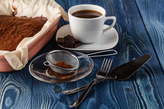 Selbst gemachter Schokoladen-Brownie in der Backpfanne gerade vom Ofen auf dunklem hölzernem Hintergrund