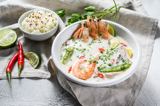 Selbst gemachter Tom Kha Gai. Kokosmilchsuppe in einer Schüssel. Thai Essen. Graue Oberfläche. Draufsicht