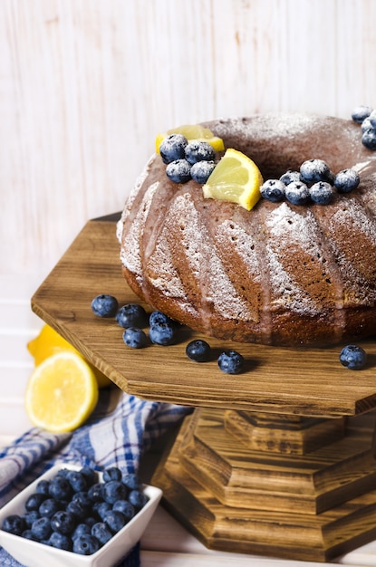 Selbst gemachter Zitronenbundtkuchen auf hölzernem Stand.