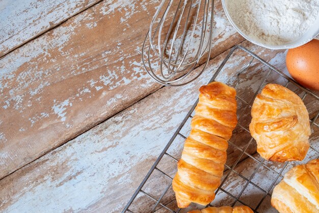 Selbst gemachtes Brot mit Ei und Schüssel Mehl auf hölzernem hinterem Boden