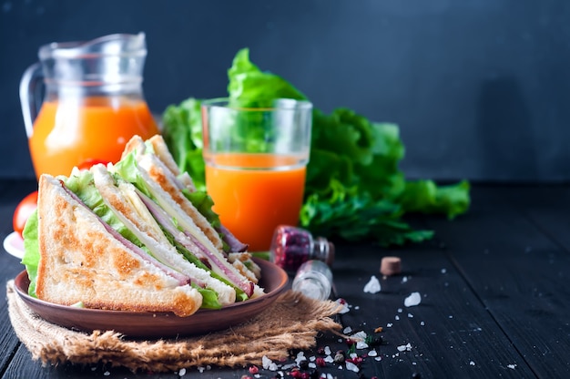 Selbst gemachtes Sandwich mit Salat und Saft als gesundes Frühstück