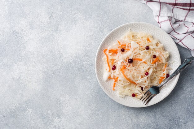 Selbst gemachtes Sauerkraut mit Karotten und Moosbeeren in der Platte. Platz kopieren