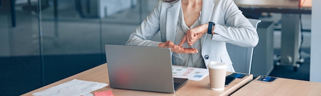 Selbstbewusste gehörlose Geschäftsfrau, die per Videoanruf an ihrem Arbeitsplatz im modernen Büro kommuniziert