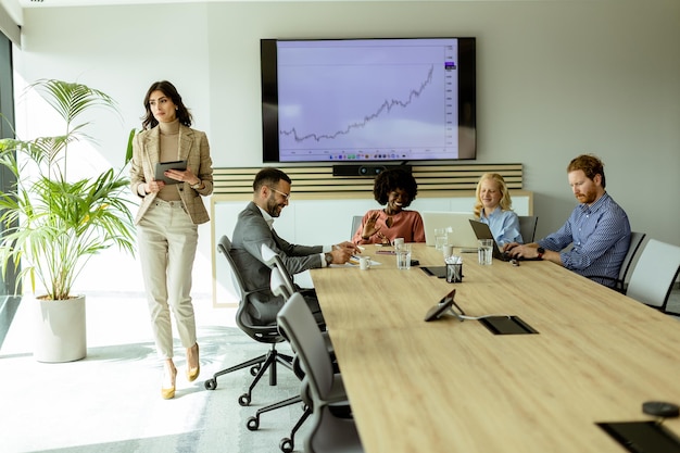 Selbstbewusste Geschäftsfrau führt mittags in einem modernen Büro ein strategisches Meeting durch