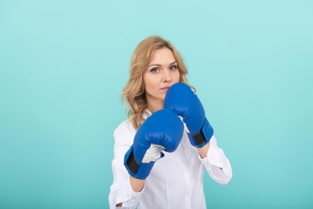 Selbstbewusste Geschäftsfrau in Boxhandschuhen. Stanzen. erfolgreicher CEO-Boxer. unerbittlicher Kampf und Erfolg. Frau bereit für den Unternehmenskampf. geschäftlicher Knockout. Chef zeigt Macht und Autorität.