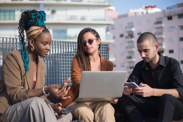 Selbstbewusste Geschäftsleute treffen sich auf dem Terrassendach. Mann und Frauen in formeller Kleidung sitzen auf dem Terrassendach, reden, essen Vorspeisen. Arbeit, moderne Technik, Teamkonzept