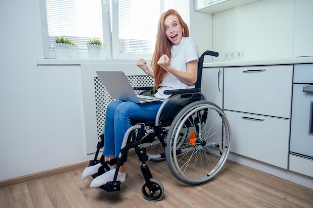 Selbstbewusste, glückliche rothaarige Ingwer-Geschäftsfrau-Studentin im Rollstuhl, die im Büro arbeitet.