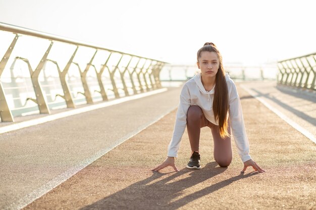 Selbstbewusste Läuferfrau in der Ausgangsposition ist laufbereit. Platz für Text