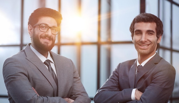 selbstbewusste professionelle Geschäftsleute posieren mit gekreuzten Armen im Büro