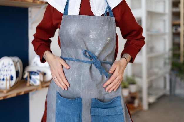 Selbstbewusste Unternehmerin bastelt Frau im Töpferstudio, die sich auf die Meisterklasse oder den Arbeitsprozess vorbereitet