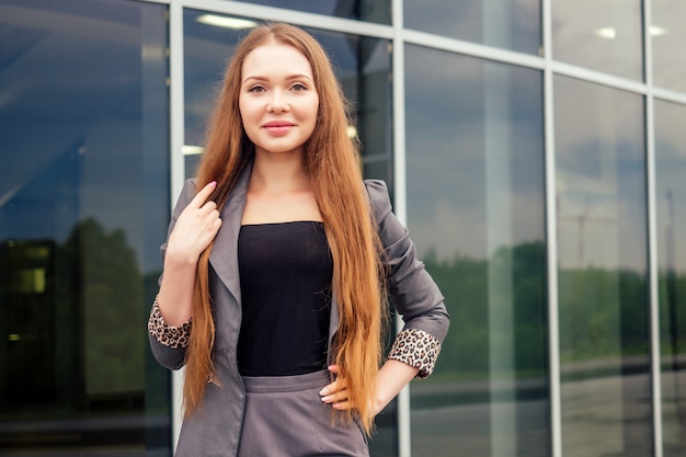 Selbstbewusste weibliche professionelle Geschäftsfrau in formeller Kleidung posiert auf der Straße Business Center Büro Wolkenkratzer Hintergrund Mode-Modell